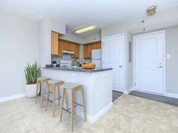 A kitchen with a counter top and three stools